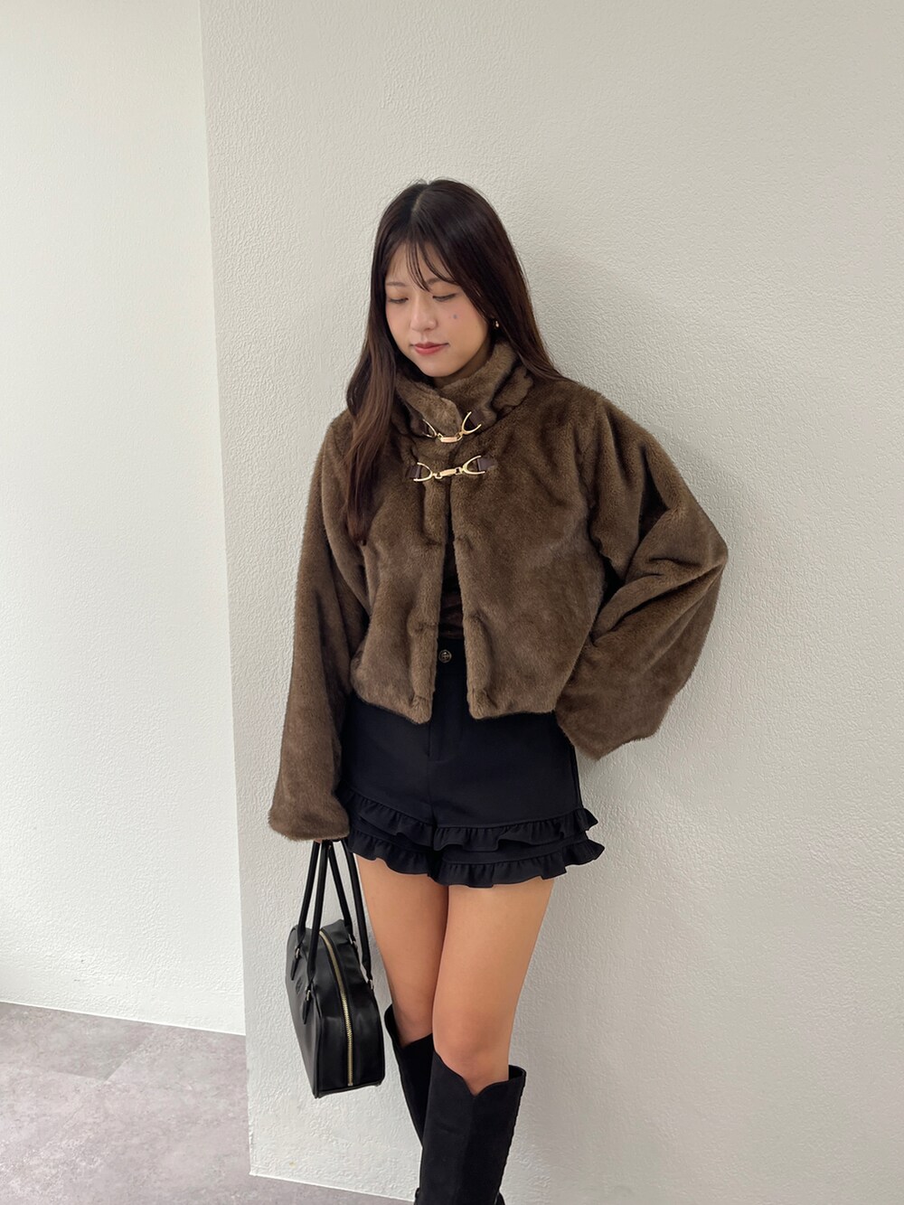 ブラウン系のブルゾン、ブラック系のブーツ、ブラック系のその他パンツを着用したレディースの秋コーディネートの2枚目の写真