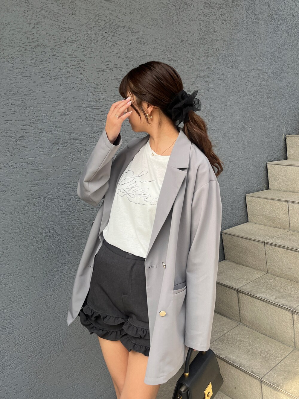 グレー系のテーラードジャケット、ホワイト系のTシャツ/カットソー、グレー系のその他パンツを着用したレディースの春コーディネートの2枚目の写真