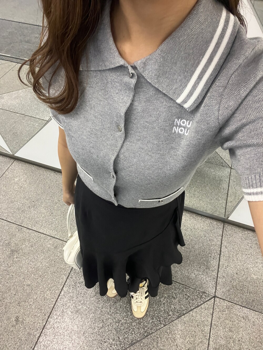 グレー系のワンピース、ブラック系のスカートを着用したレディースの春コーディネートの5枚目の写真