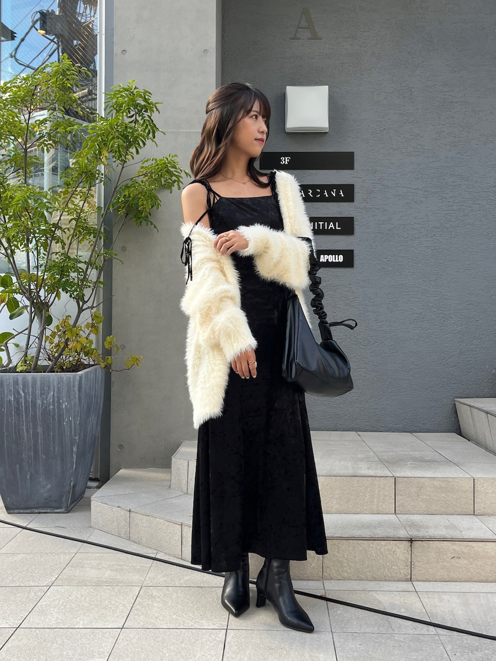 ホワイト系のカーディガン/ボレロ、ブラック系のワンピース、ブラック系のブーツを着用したレディースの秋コーディネートの4枚目の写真