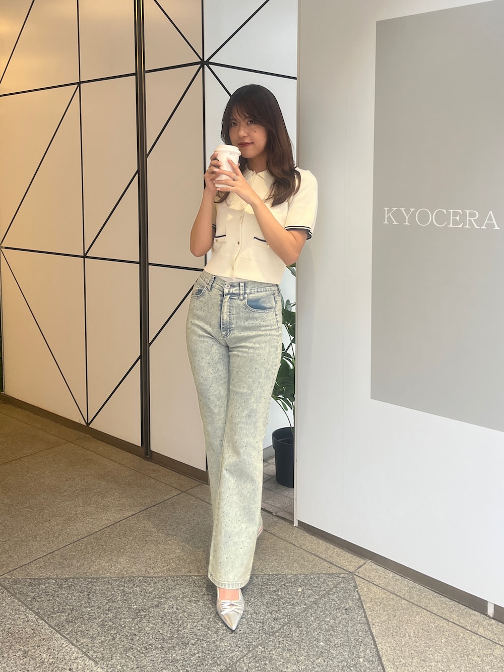 ホワイト系のワンピース、ブルー系のデニムパンツを着用したレディースの春コーディネートの2枚目の写真