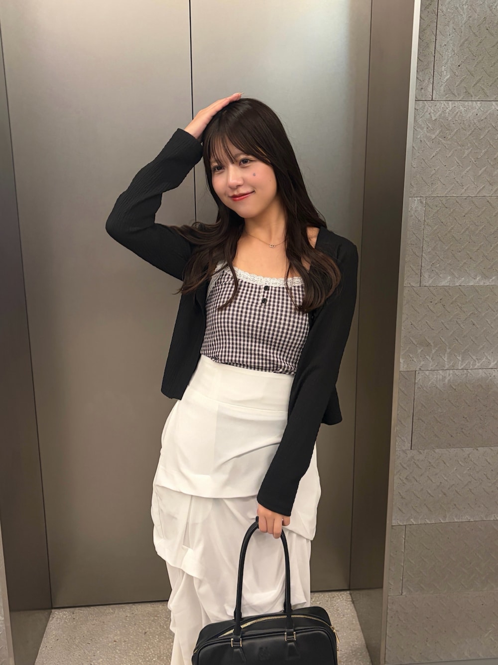 ブラック系のTシャツ/カットソー、ホワイト系のスカートを着用したレディースの冬コーディネートの4枚目の写真