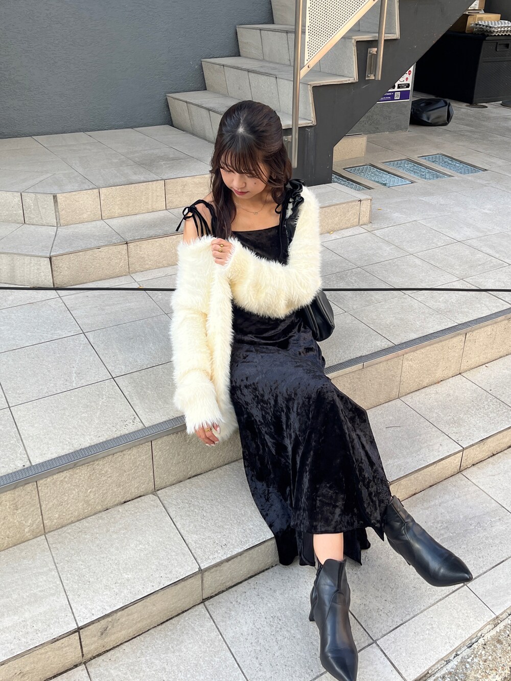 ホワイト系のカーディガン/ボレロ、ブラック系のワンピース、ブラック系のブーツを着用したレディースの秋コーディネートの5枚目の写真