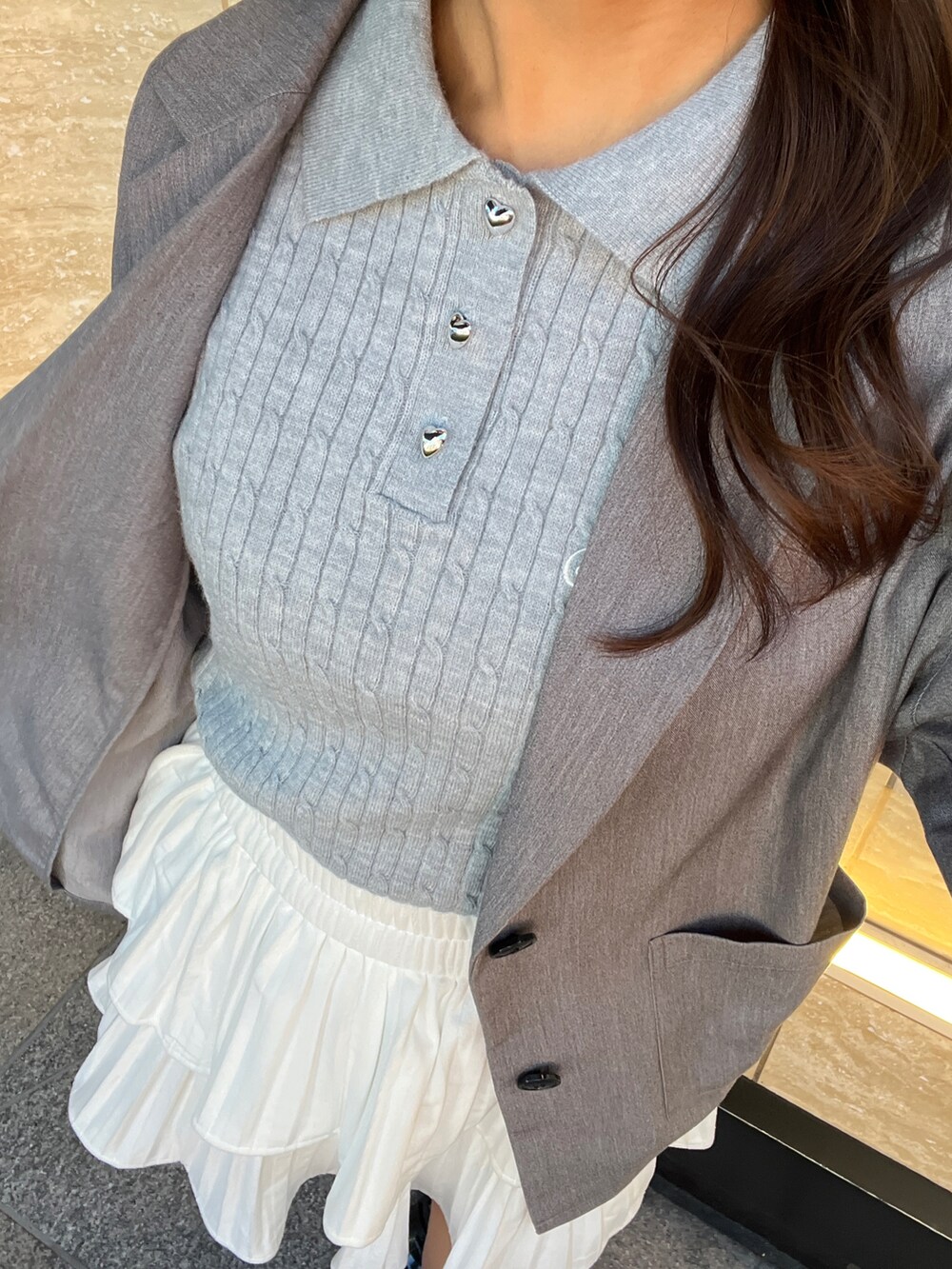 グレー系のテーラードジャケット、ブルー系のニット/セーター、ホワイト系のスカートを着用したレディースの冬コーディネートの5枚目の写真