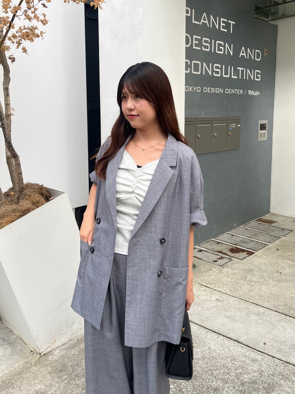 ベージュ系のTシャツ/カットソー、グレー系のテーラードジャケットを着用したレディースの夏コーディネートの2枚目の写真