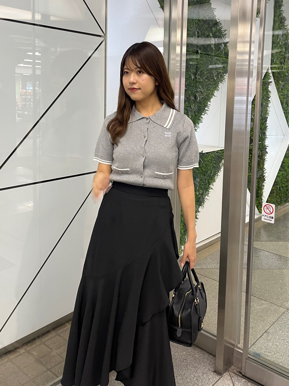 グレー系のワンピース、ブラック系のスカートを着用したレディースの春コーディネートの4枚目の写真