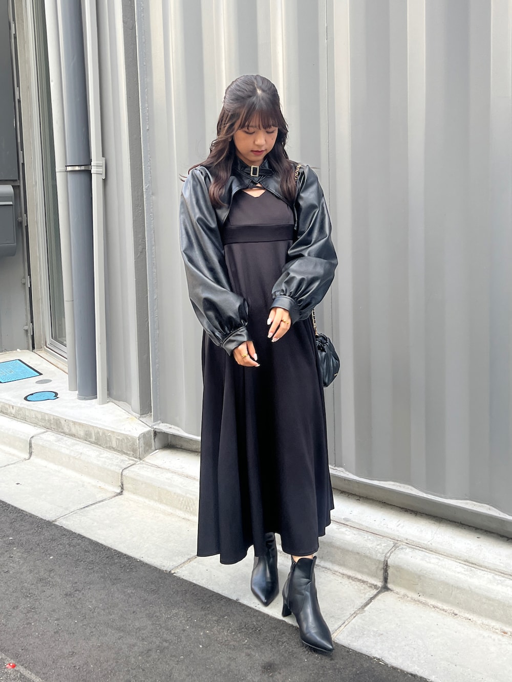 ブラック系のワンピース、ブラック系のその他アウターを着用したレディースの秋コーディネートの2枚目の写真