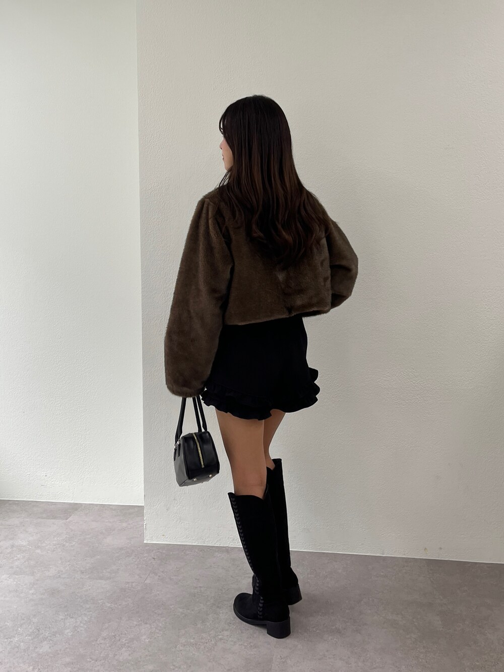 ブラウン系のブルゾン、ブラック系のブーツ、ブラック系のその他パンツを着用したレディースの秋コーディネートの3枚目の写真