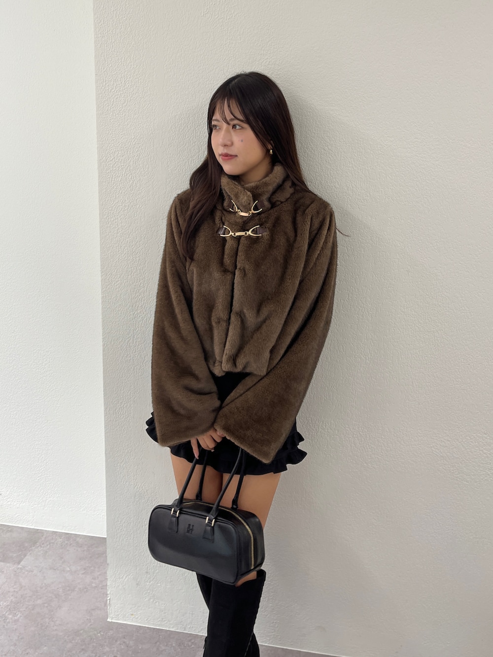 ブラウン系のブルゾン、ブラック系のブーツ、ブラック系のその他パンツを着用したレディースの秋コーディネートの5枚目の写真