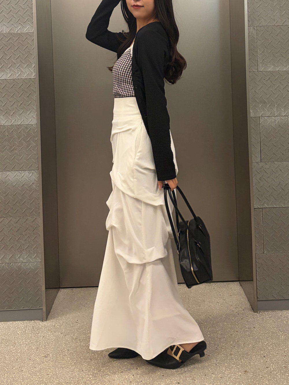 ブラック系のTシャツ/カットソー、ホワイト系のスカートを着用したレディースの冬コーディネートの5枚目の写真