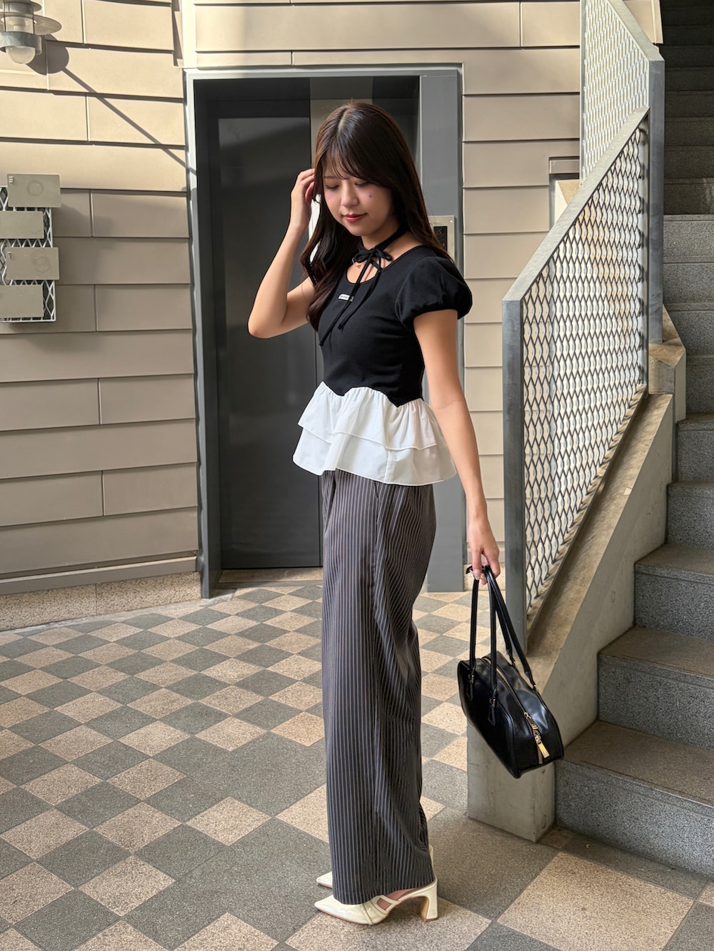 ブラック系のTシャツ/カットソーを着用したレディースの夏コーディネートの2枚目の写真