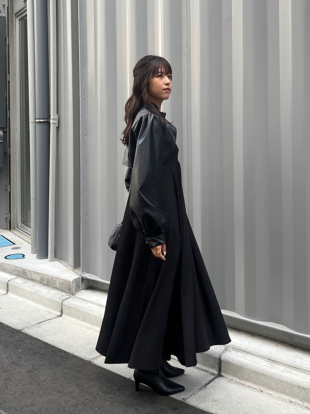 ブラック系のワンピース、ブラック系のその他アウターを着用したレディースの秋コーディネートの4枚目の写真