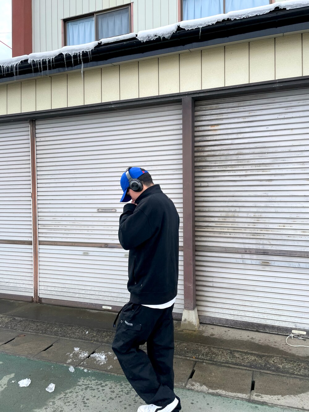 ブラック系のその他トップス、ホワイト系のスニーカー、ブラック系のカーゴパンツを着用したメンズの春コーディネートの2枚目の写真