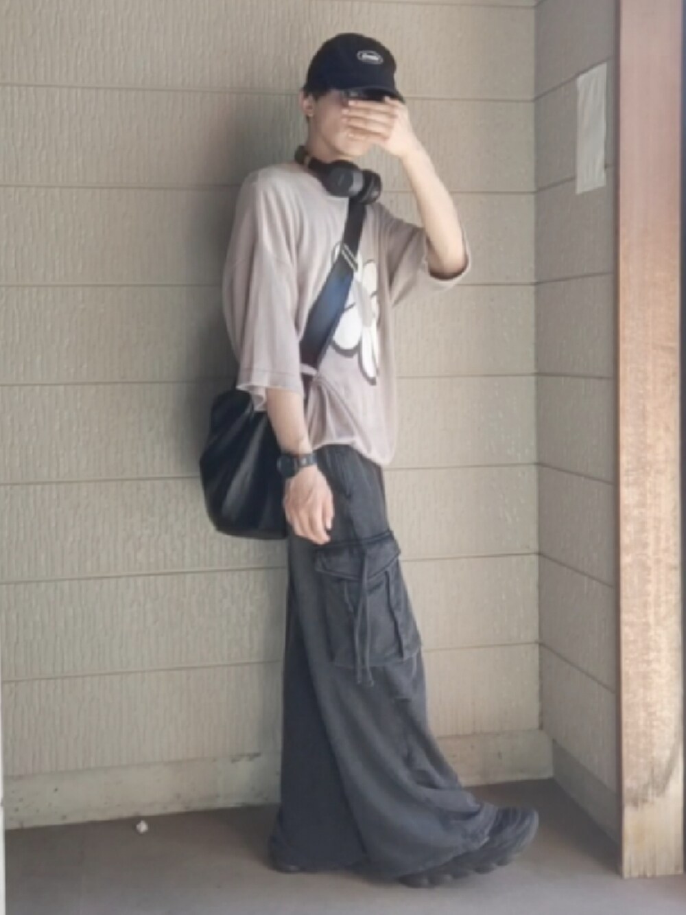 ブラック系のカーゴパンツ、ベージュ系のニット/セーター、ブラック系のショルダーバッグを着用したメンズの夏コーディネートの2枚目の写真