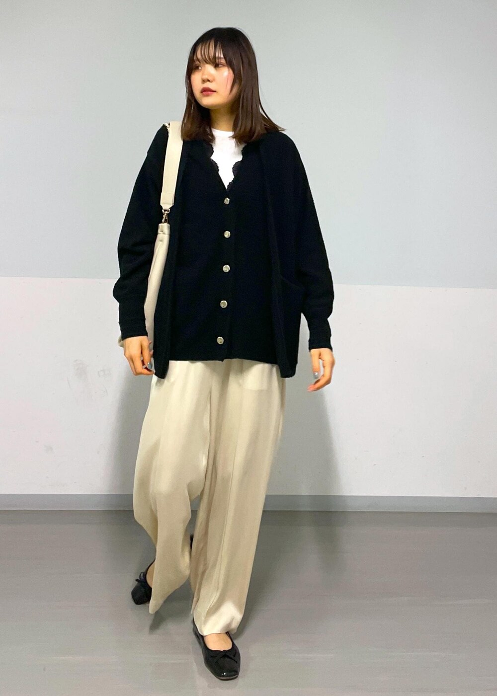 ベージュ系のその他パンツ、ブラック系のカーディガン/ボレロ、ベージュ系のトートバッグを着用したレディースの冬コーディネートの8枚目の写真