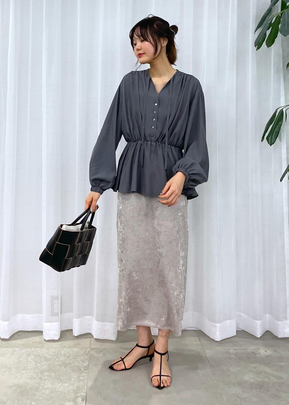 ブラック系のトートバッグ、ベージュ系のスカート、グレー系のシャツ/ブラウスを着用したレディースの冬コーディネートの7枚目の写真