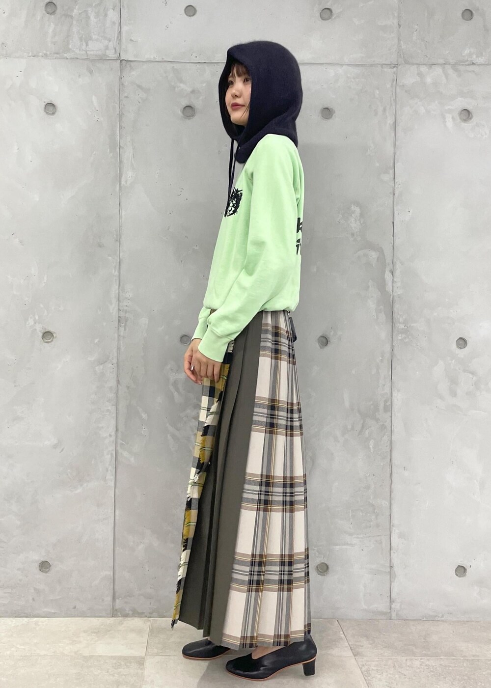 イエロー系のスカート、グリーン系のスウェット、ブラック系のショルダーバッグを着用したレディースの夏コーディネートの3枚目の写真