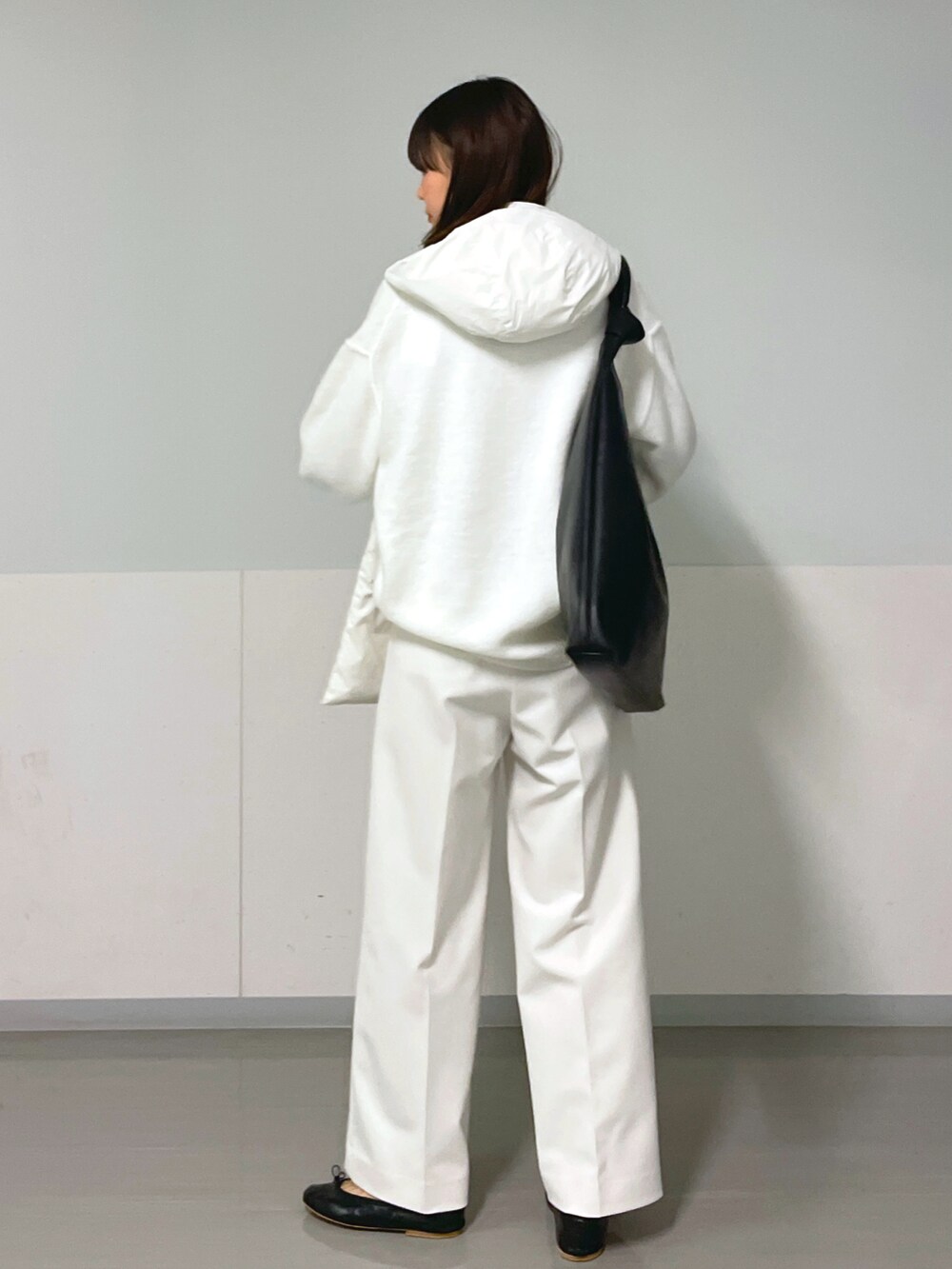 ホワイト系のニット/セーター、ブラック系のバレエシューズ、ブラック系のトートバッグを着用したレディースの冬コーディネートの3枚目の写真