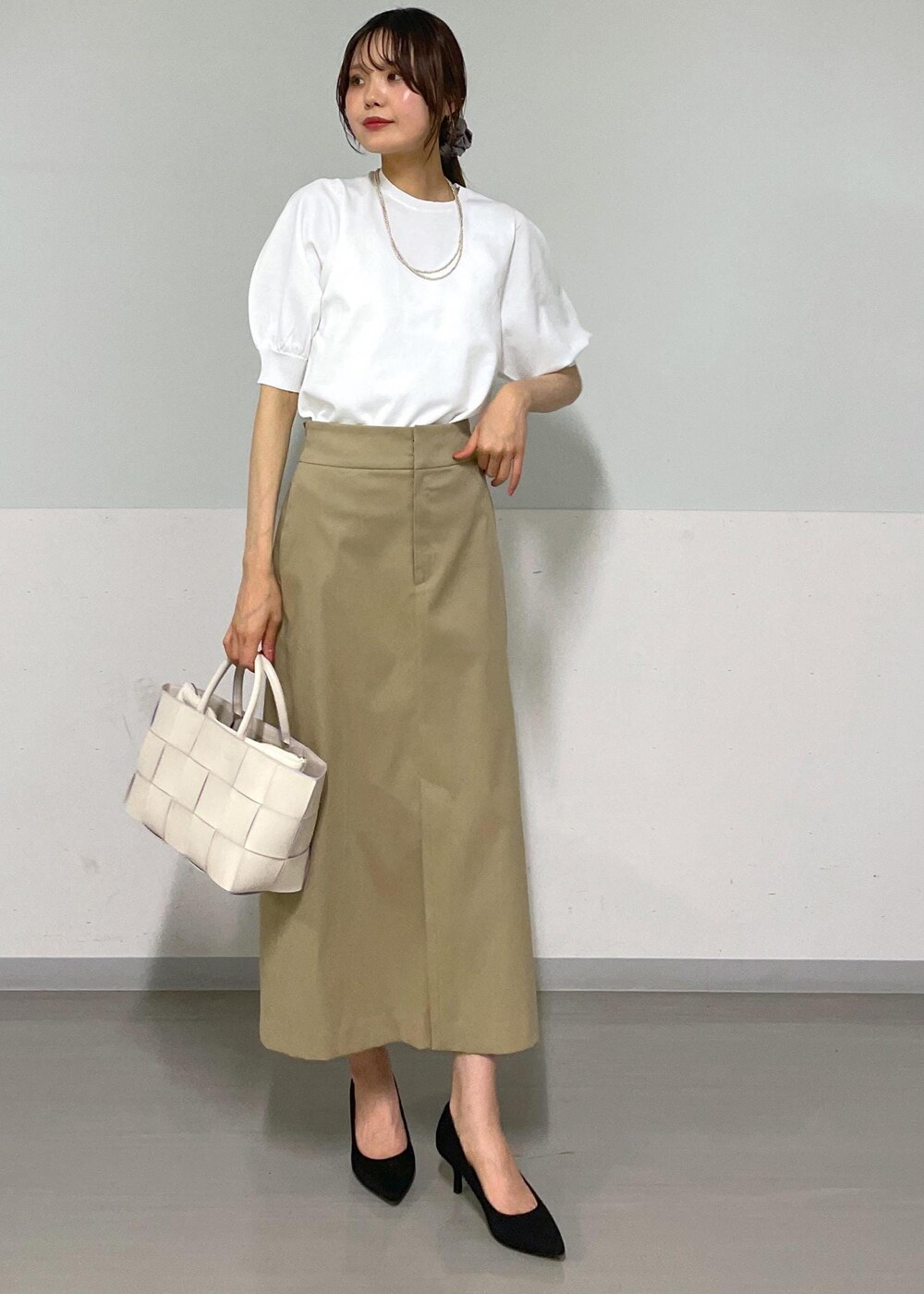 ホワイト系のトートバッグ、ベージュ系のスカート、ベージュ系のカーディガン/ボレロを着用したレディースの夏コーディネートの4枚目の写真