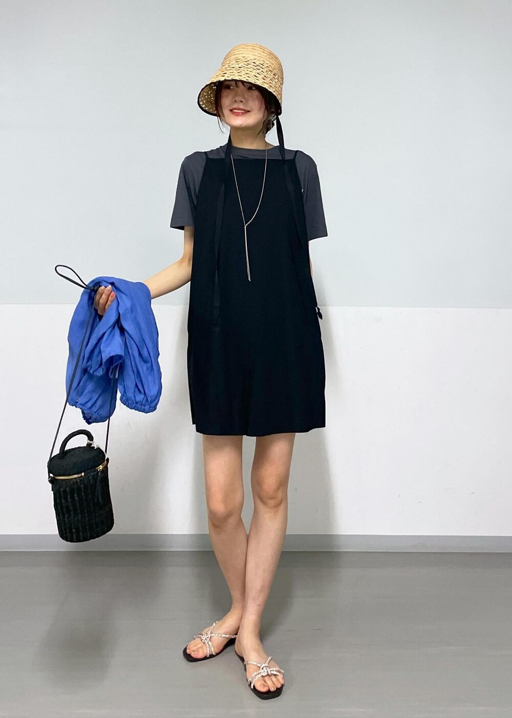 ブラック系のショルダーバッグ、ゴールド系のサンダル、ブラック系のTシャツ/カットソーを着用したレディースの夏コーディネートの7枚目の写真