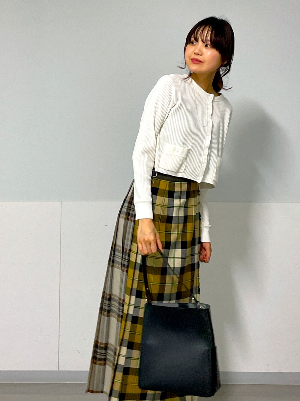 ホワイト系のカーディガン/ボレロ、イエロー系のスカート、ベージュ系のスニーカーを着用したレディースの秋コーディネートの5枚目の写真