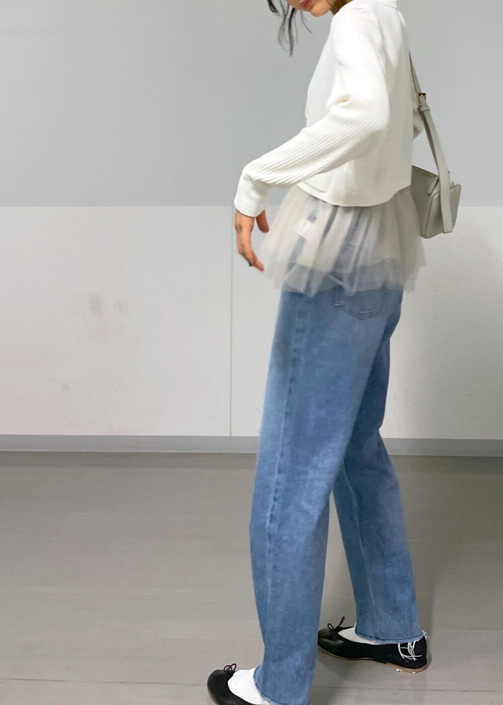 ブラック系のバレエシューズ、ホワイト系のカーディガン/ボレロ、ブルー系のデニムパンツを着用したレディースの秋コーディネートの7枚目の写真