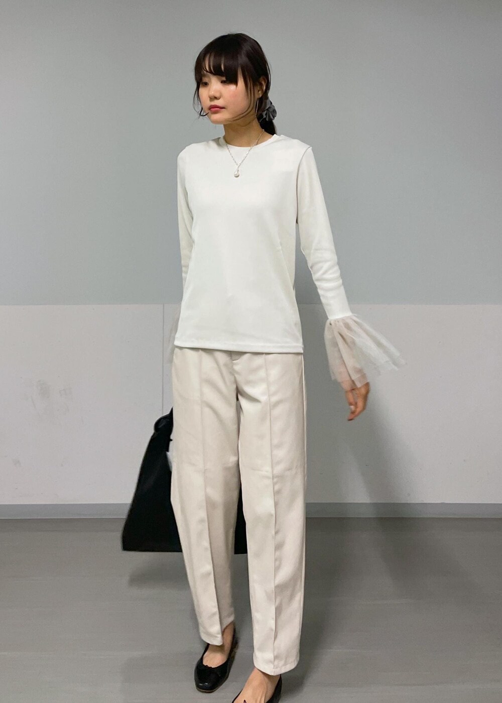 ベージュ系のジャンパースカート、ホワイト系のTシャツ/カットソー、ブラック系のバレエシューズを着用したレディースの秋コーディネートの7枚目の写真