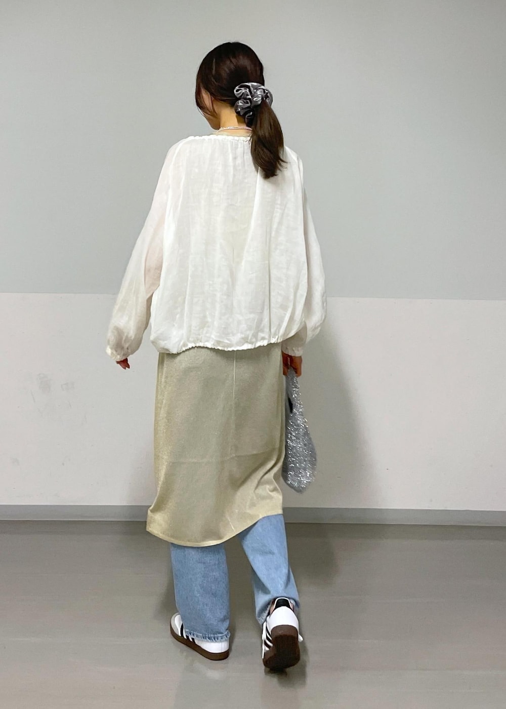 ホワイト系のキャミソール、ホワイト系のブルゾン、シルバー系のハンドバッグを着用したレディースの夏コーディネートの4枚目の写真