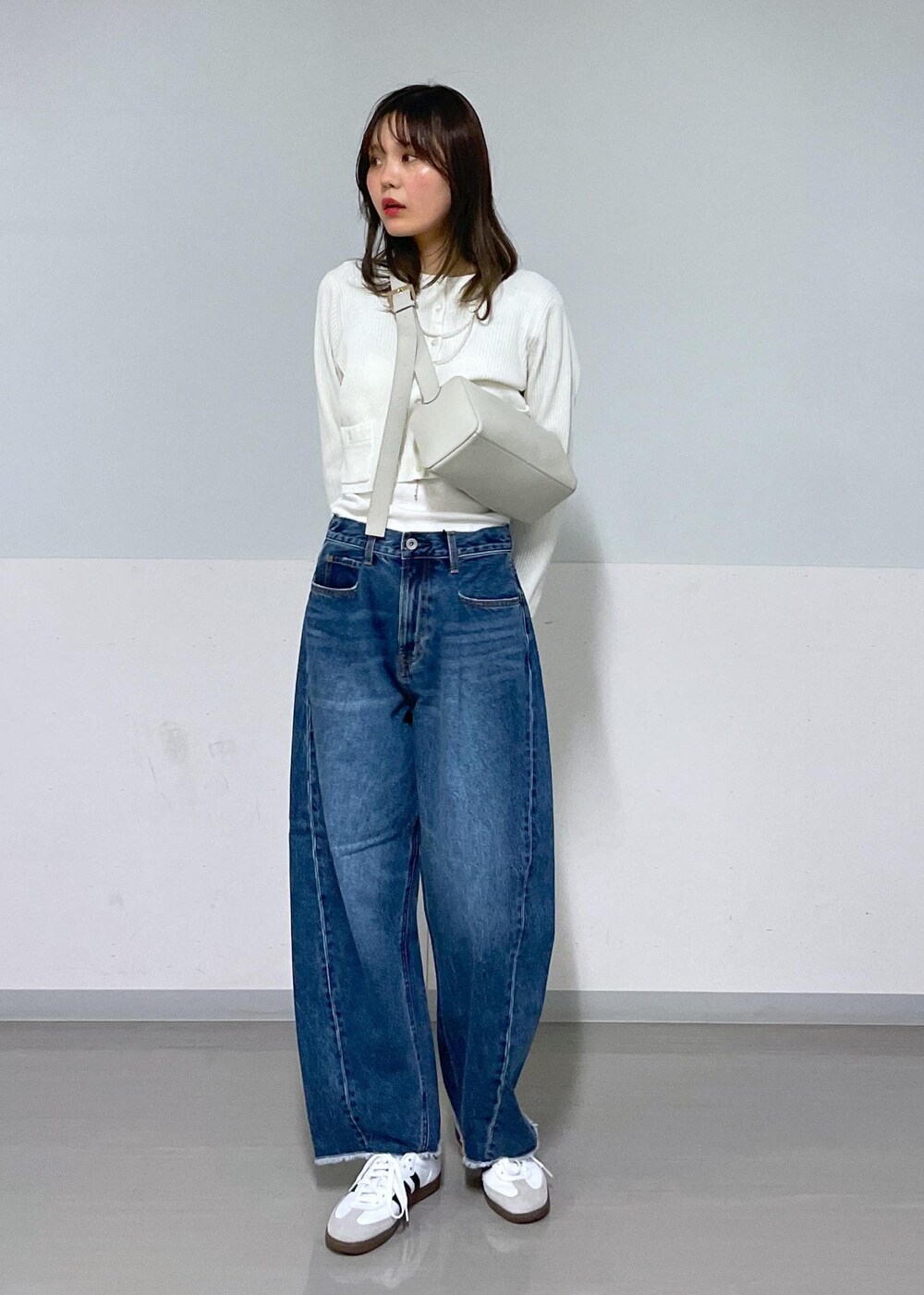 グレー系のショルダーバッグ、ホワイト系のカーディガン/ボレロ、グレー系のTシャツ/カットソーを着用したレディースの夏コーディネートの2枚目の写真