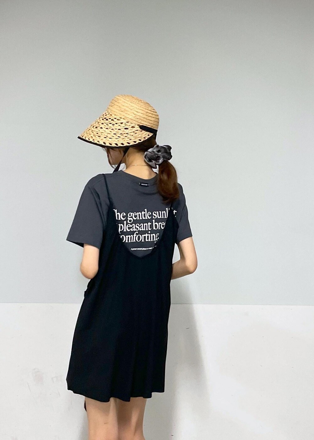 ブラック系のショルダーバッグ、ゴールド系のサンダル、ブラック系のTシャツ/カットソーを着用したレディースの夏コーディネートの6枚目の写真