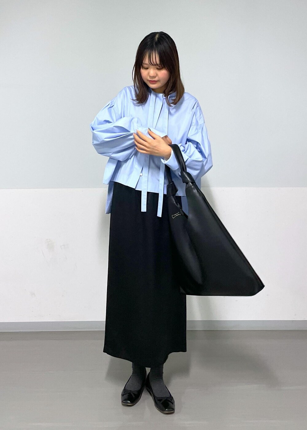 ブルー系のシャツ/ブラウス、ブラック系のトートバッグ、ブラック系のスカートを着用したレディースの冬コーディネートの8枚目の写真