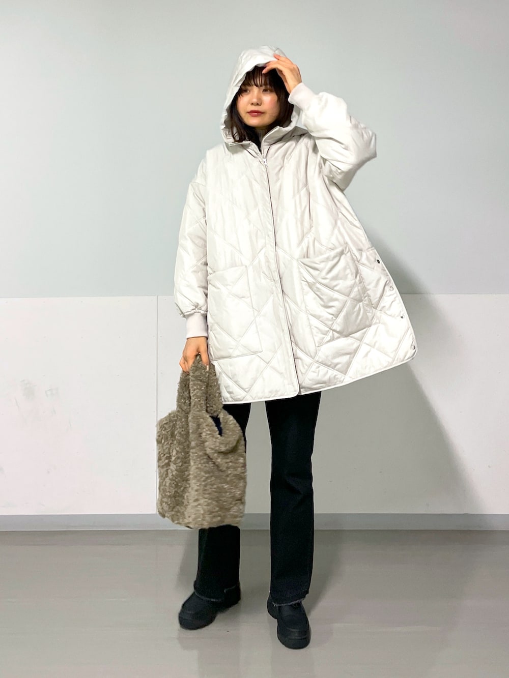 グレー系のブルゾン、グレー系のデニムパンツ、ブラック系のスニーカーを着用したレディースの冬コーディネートの5枚目の写真