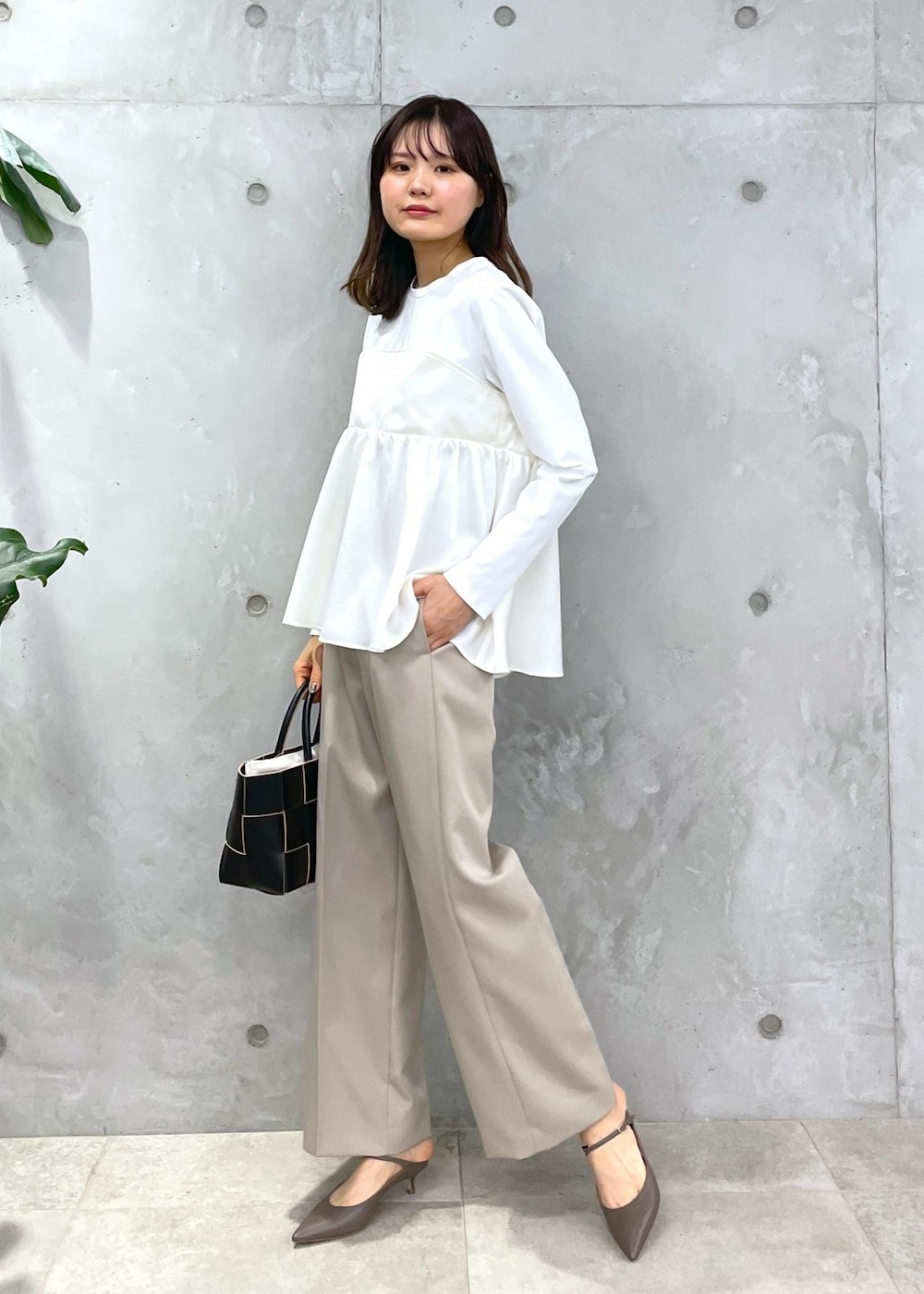 ベージュ系のその他パンツ、ブラック系のトートバッグ、ホワイト系のTシャツ/カットソーを着用したレディースの冬コーディネートの2枚目の写真