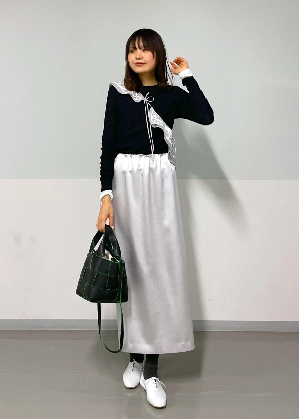 ブラック系のトートバッグ、ホワイト系のその他シューズ、ブラック系のTシャツ/カットソーを着用したレディースの冬コーディネートの8枚目の写真
