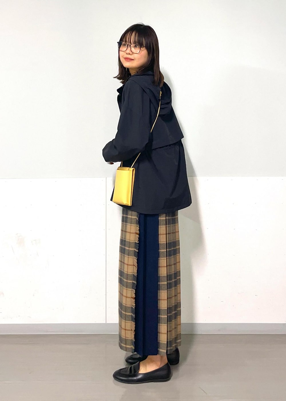 イエロー系のショルダーバッグ、ホワイト系のTシャツ/カットソー、ベージュ系のスカートを着用したレディースの秋コーディネートの4枚目の写真