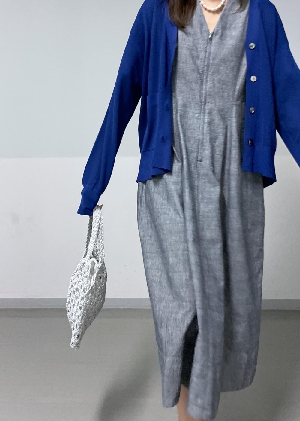 ブラック系のサンダル、ホワイト系のハンドバッグ、ブルー系のカーディガン/ボレロを着用したレディースの夏コーディネートの3枚目の写真