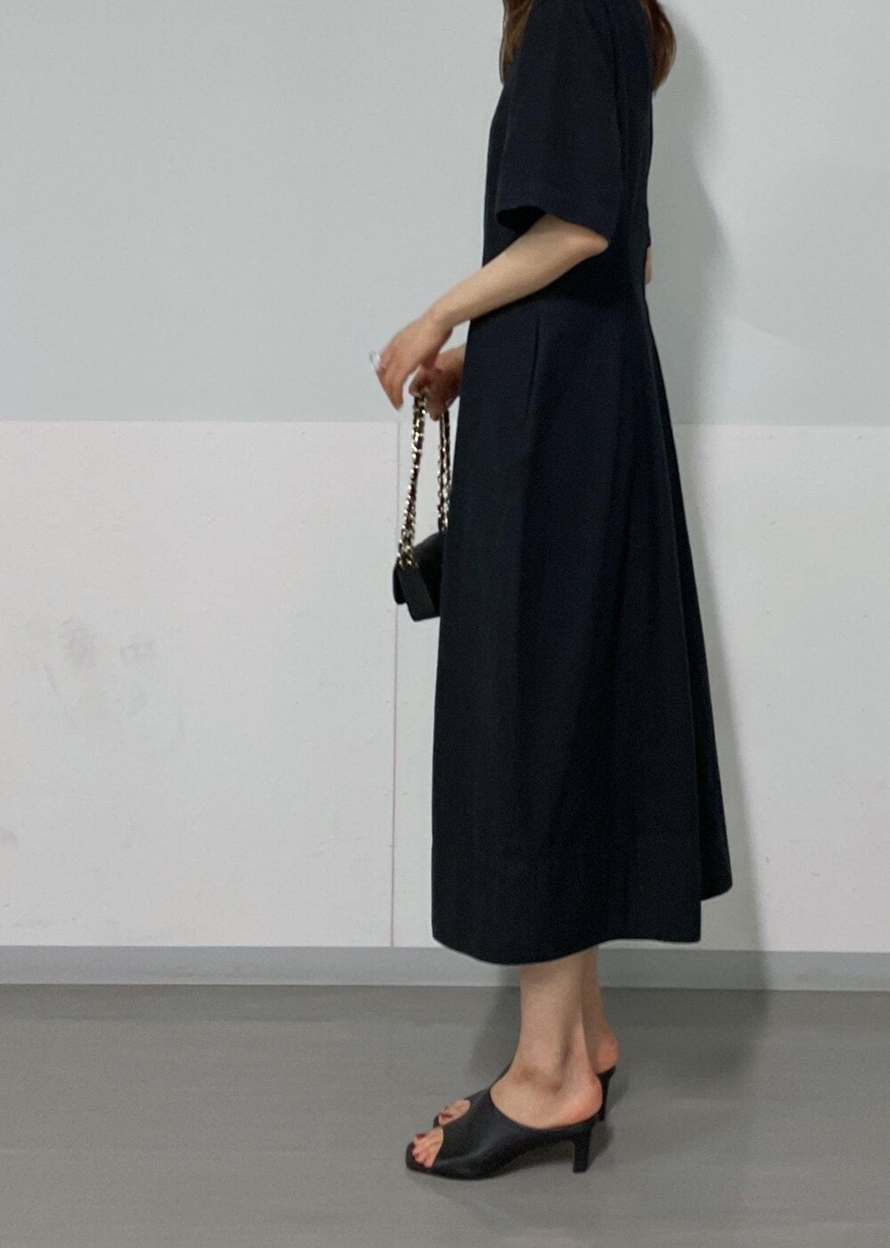 ブラック系のサンダル、ホワイト系のカーディガン/ボレロ、ブラック系のワンピースを着用したレディースの夏コーディネートの5枚目の写真