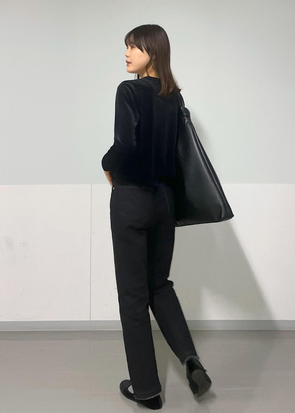 グレー系のTシャツ/カットソー、ブラック系のトートバッグ、グレー系のデニムパンツを着用したレディースの冬コーディネートの3枚目の写真