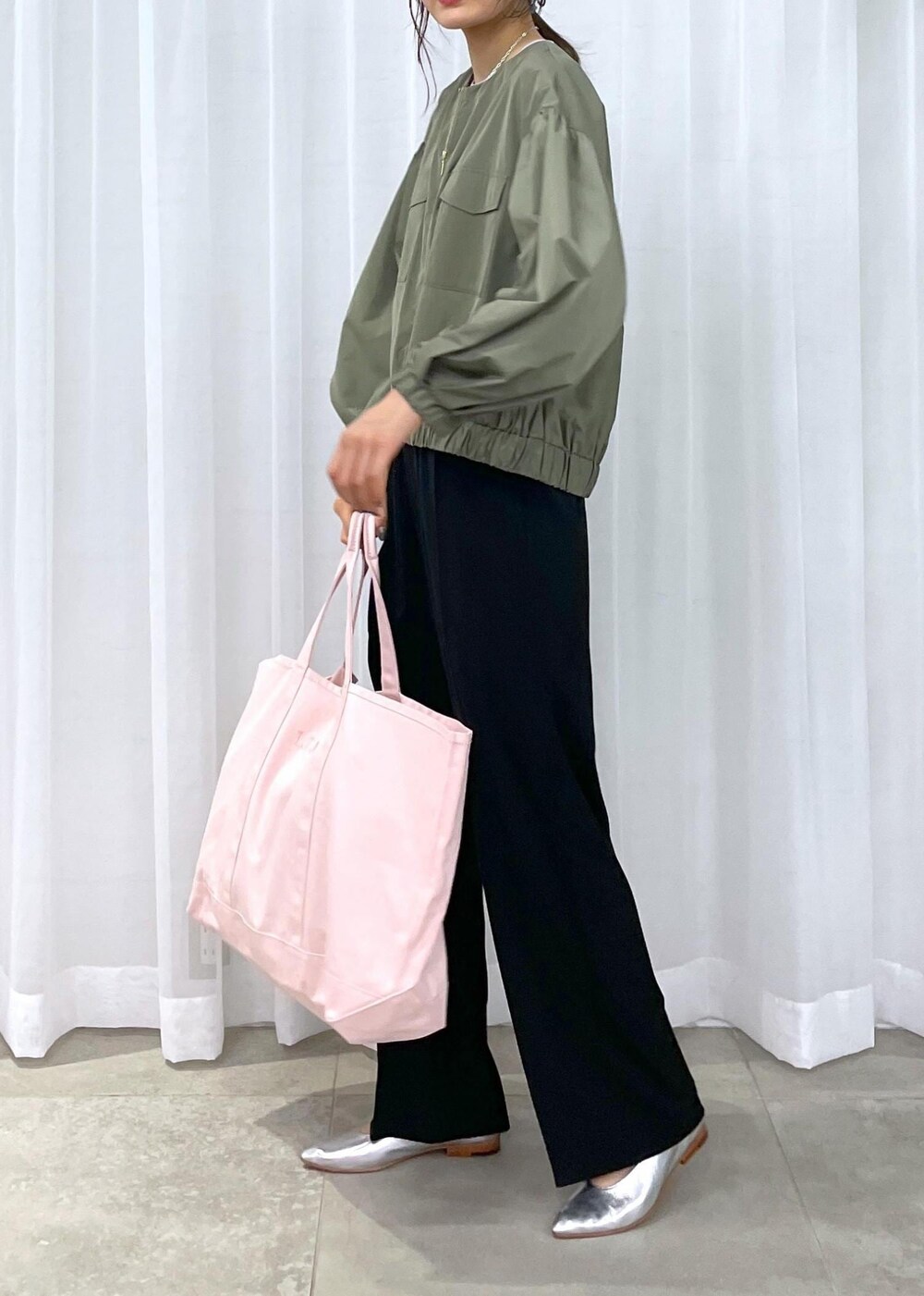 ブラック系のスラックス、グリーン系のブルゾン、シルバー系のパンプスを着用したレディースの冬コーディネートの10枚目の写真