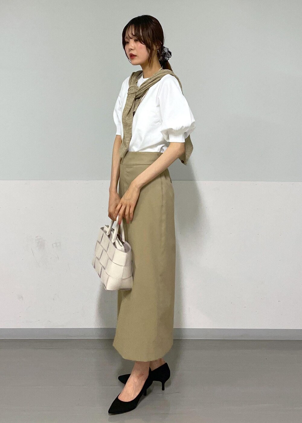 ホワイト系のトートバッグ、ベージュ系のスカート、ベージュ系のカーディガン/ボレロを着用したレディースの夏コーディネートの2枚目の写真