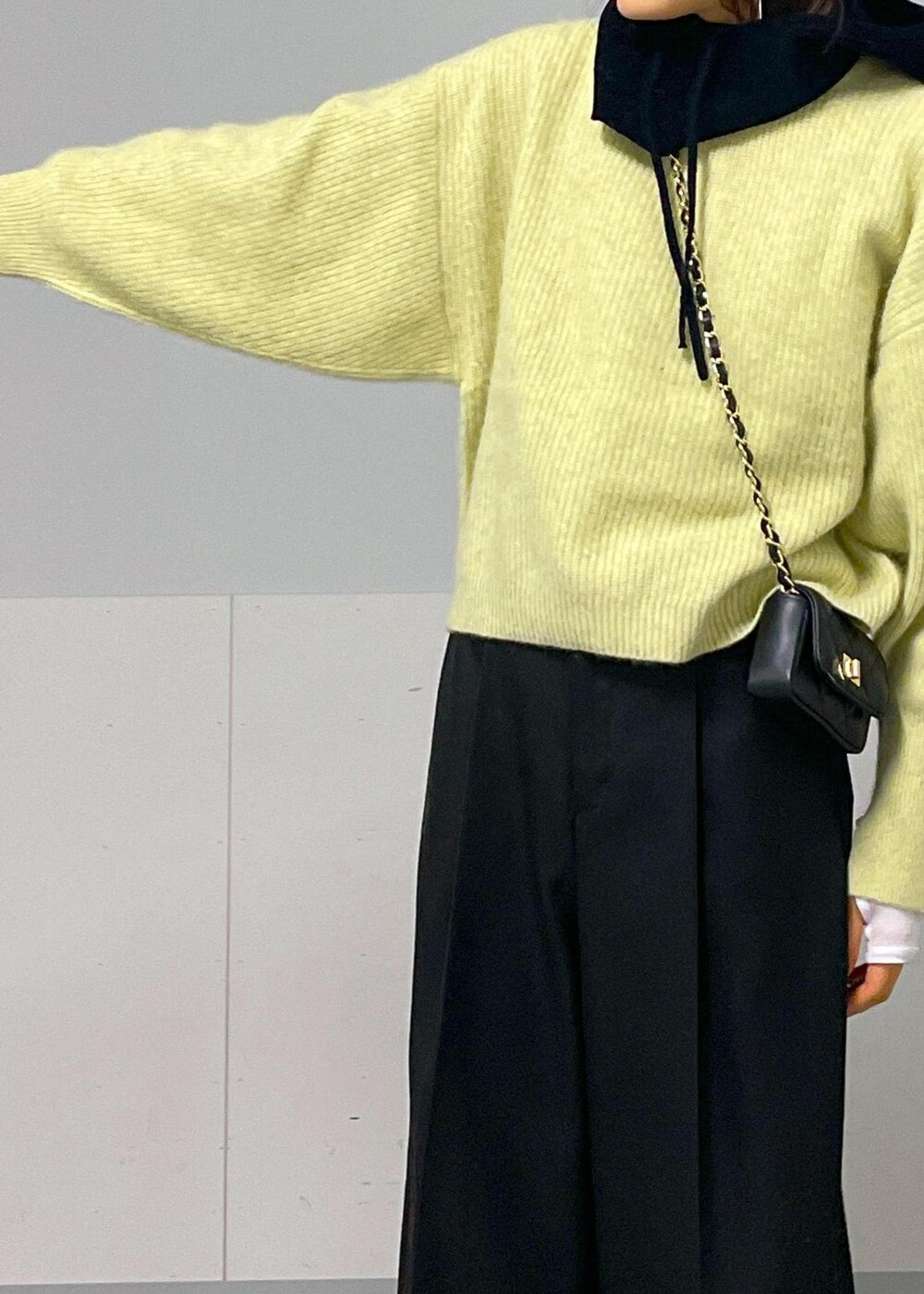 ブラック系のショルダーバッグ、イエロー系のニット/セーター、ホワイト系のTシャツ/カットソーを着用したレディースの秋コーディネートの8枚目の写真