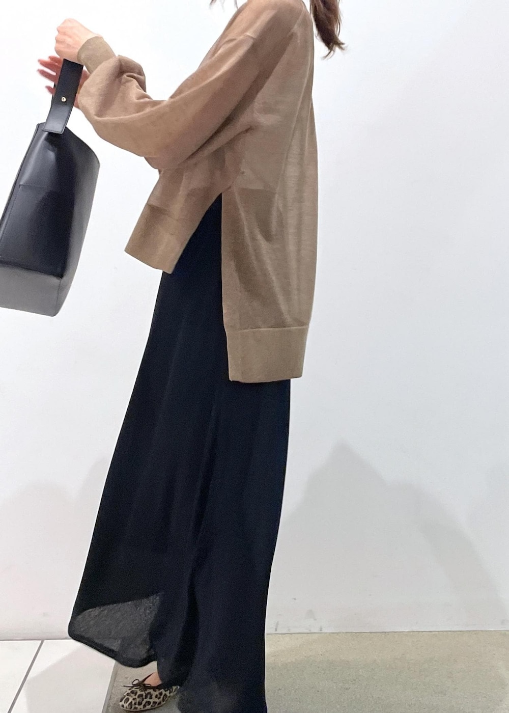 ブラック系のスカート、ゴールド系のTシャツ/カットソー、ブラック系のトートバッグを着用したレディースの夏コーディネートの3枚目の写真