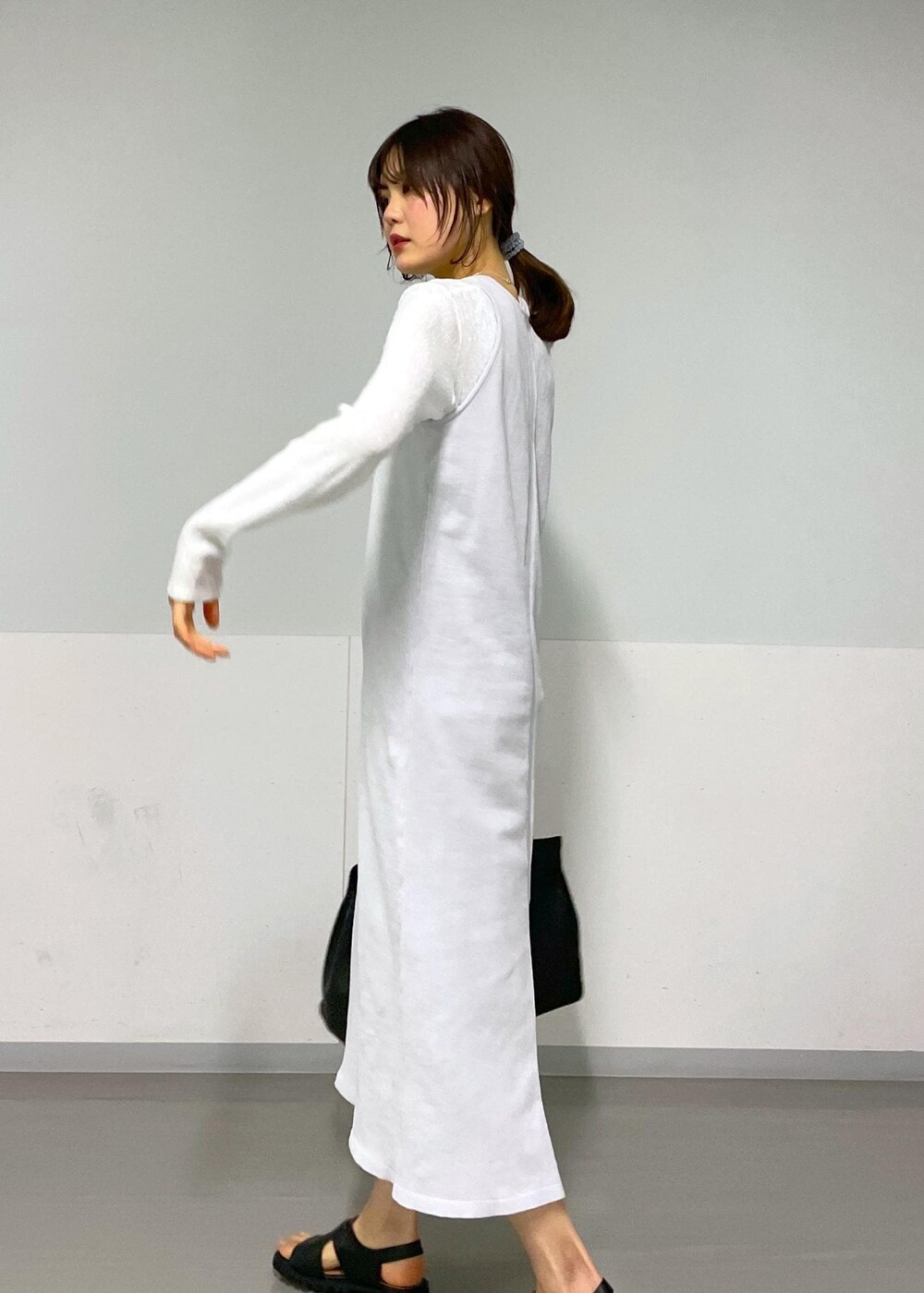 ブラック系のサンダル、グレー系のワンピース、ホワイト系のTシャツ/カットソーを着用したレディースの冬コーディネートの9枚目の写真