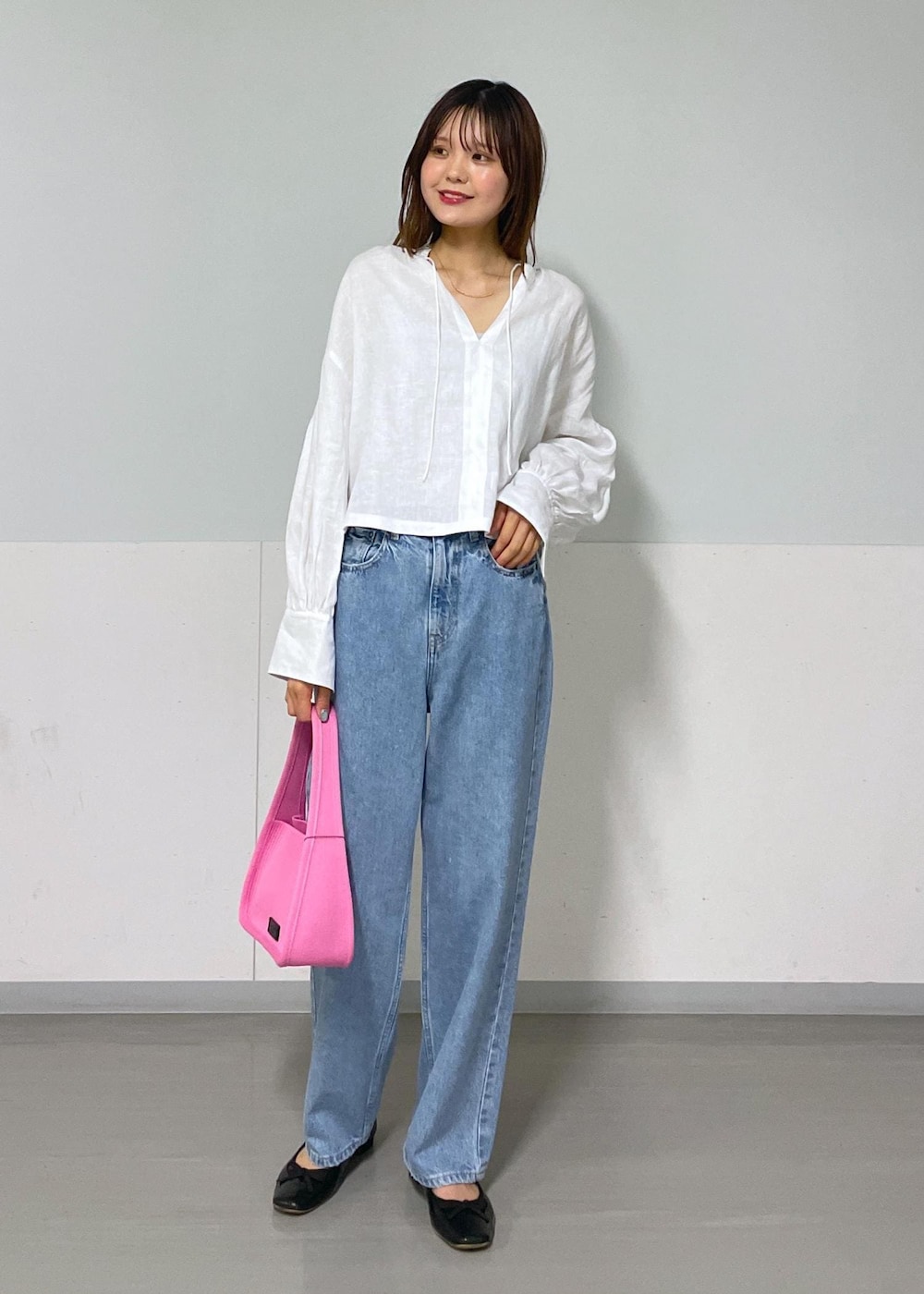 グレー系のタンクトップ、ピンク系のハンドバッグ、ホワイト系のシャツ/ブラウスを着用したレディースの夏コーディネートの2枚目の写真