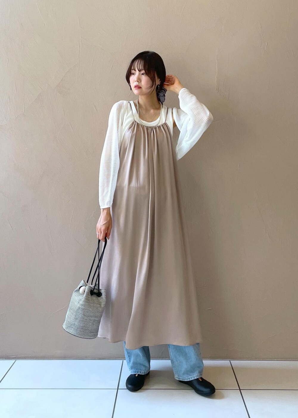 ブラック系のショルダーバッグ、ホワイト系のタンクトップ、ホワイト系のカーディガン/ボレロを着用したレディースの夏コーディネートの2枚目の写真