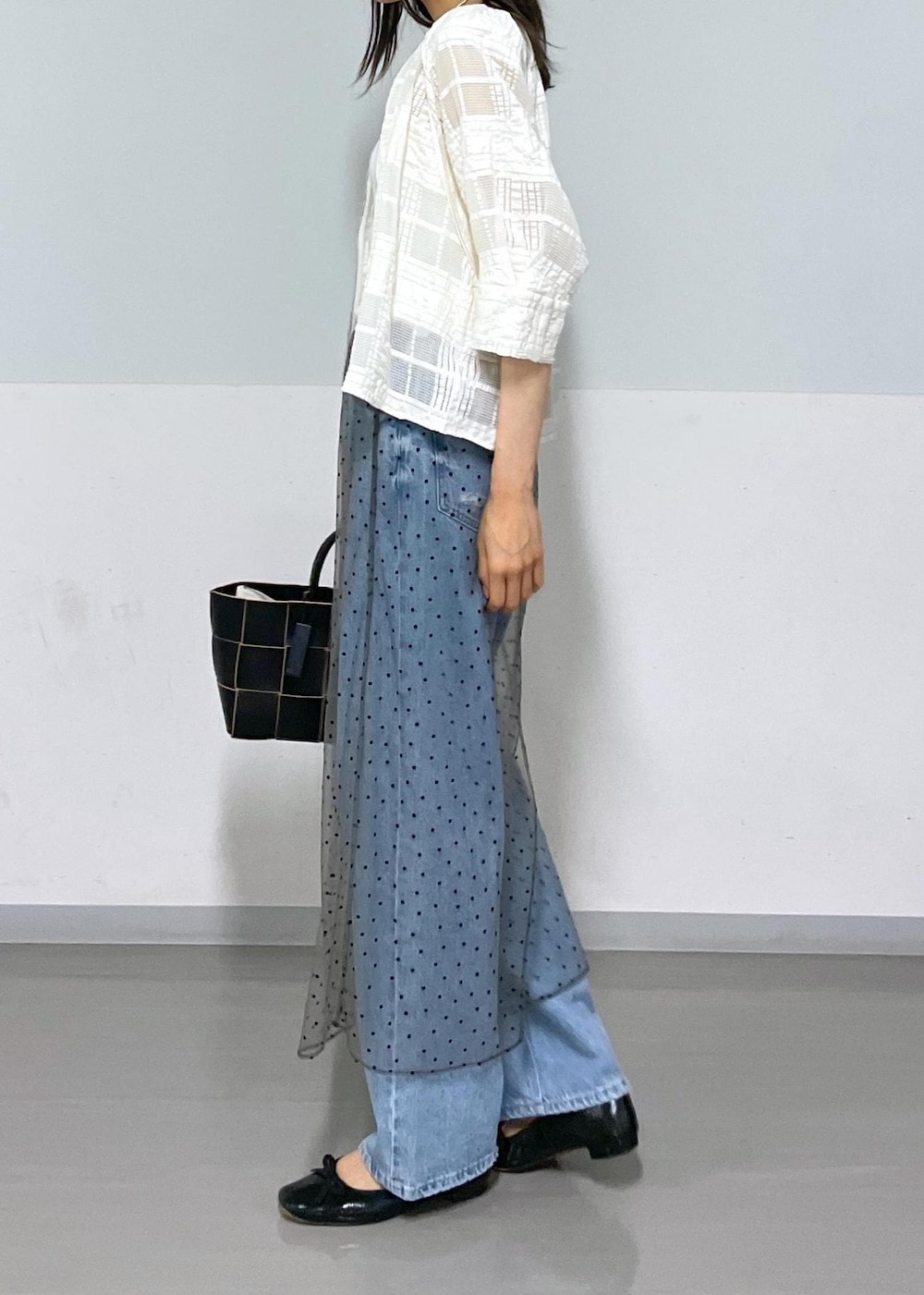 ブラック系のトートバッグ、ホワイト系のタンクトップ、グレー系のスカートを着用したレディースの夏コーディネートの4枚目の写真
