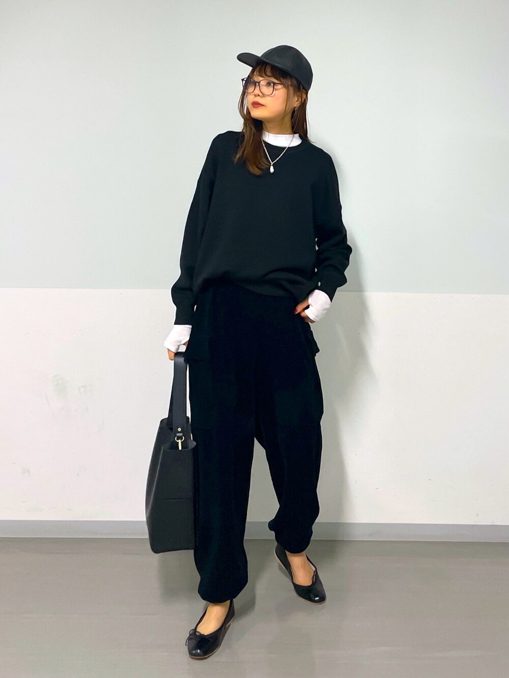 ブラック系のスウェット、ブラック系のカーゴパンツ、ホワイト系のTシャツ/カットソーを着用したレディースの秋コーディネートの2枚目の写真