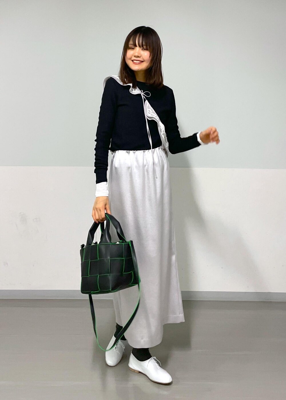 ブラック系のトートバッグ、ホワイト系のその他シューズ、ブラック系のTシャツ/カットソーを着用したレディースの冬コーディネートの9枚目の写真
