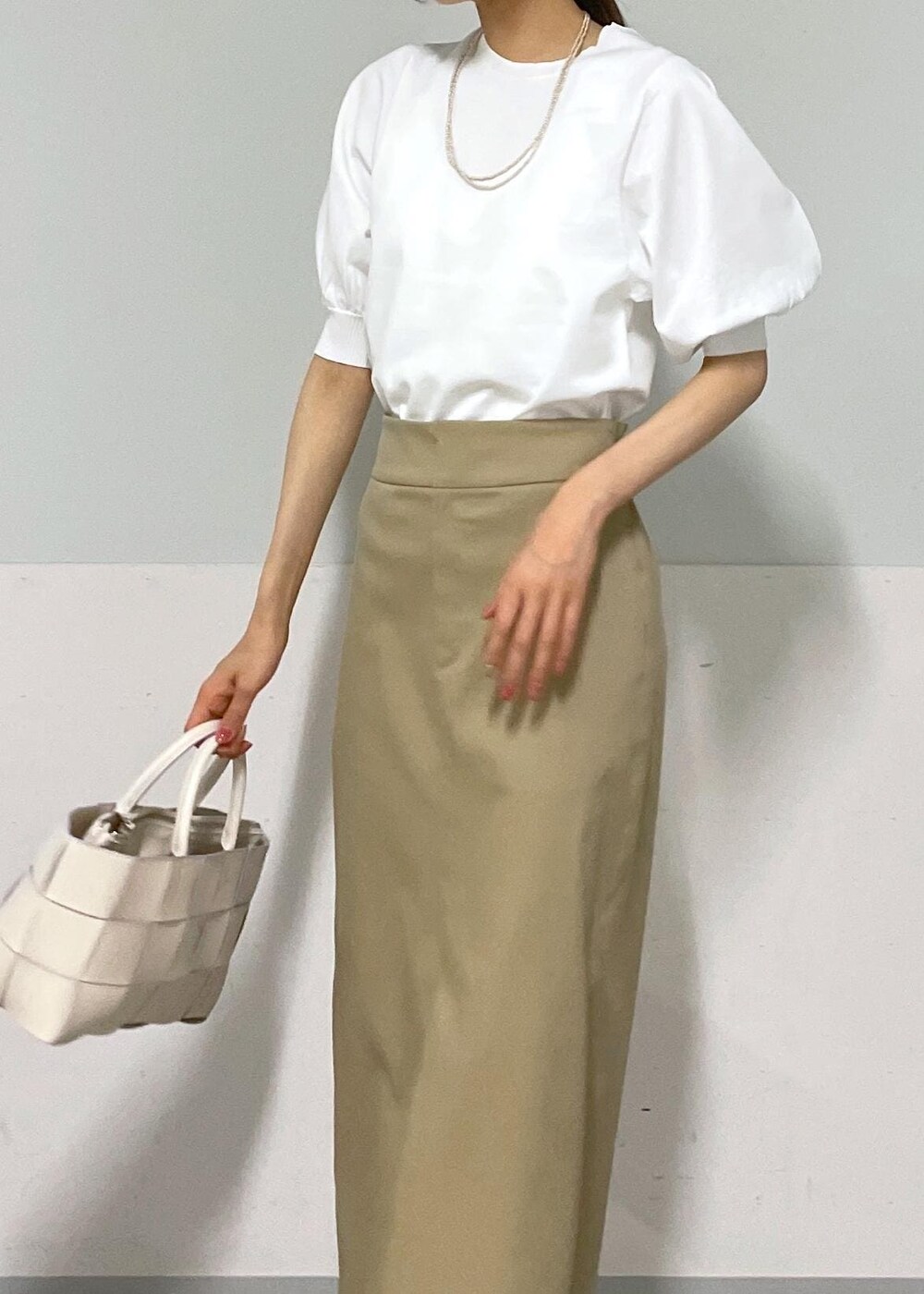 ホワイト系のトートバッグ、ベージュ系のスカート、ベージュ系のカーディガン/ボレロを着用したレディースの夏コーディネートの6枚目の写真