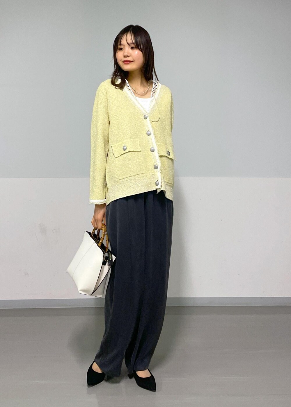 イエロー系のカーディガン/ボレロ、ホワイト系のTシャツ/カットソー、グレー系のその他パンツを着用したレディースの春コーディネートの10枚目の写真